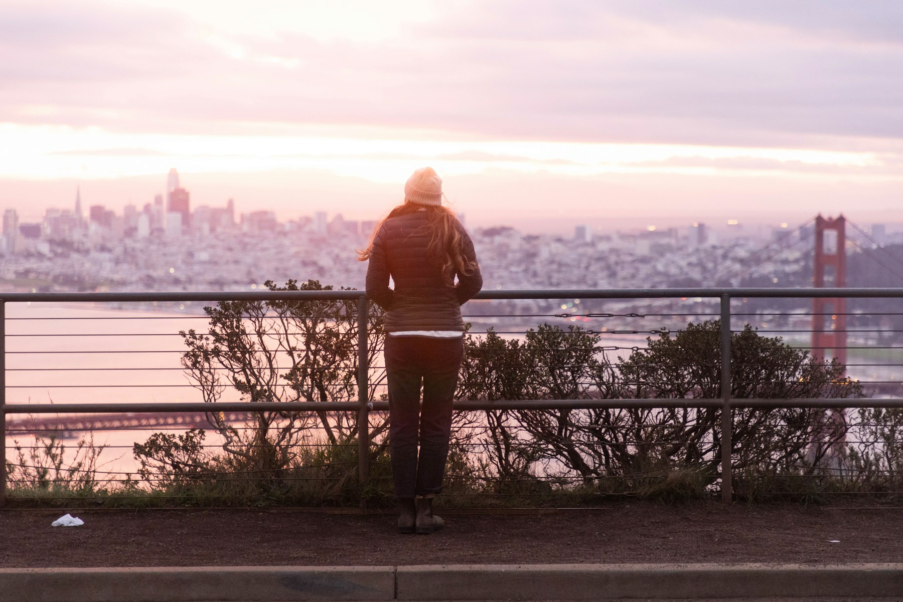 A person looking over a city at sunset